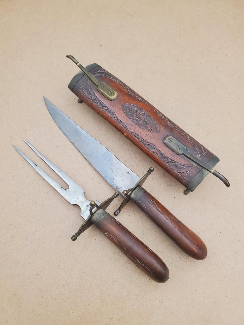 Vintage fork and knife set in a handmade carved wooden display with brass